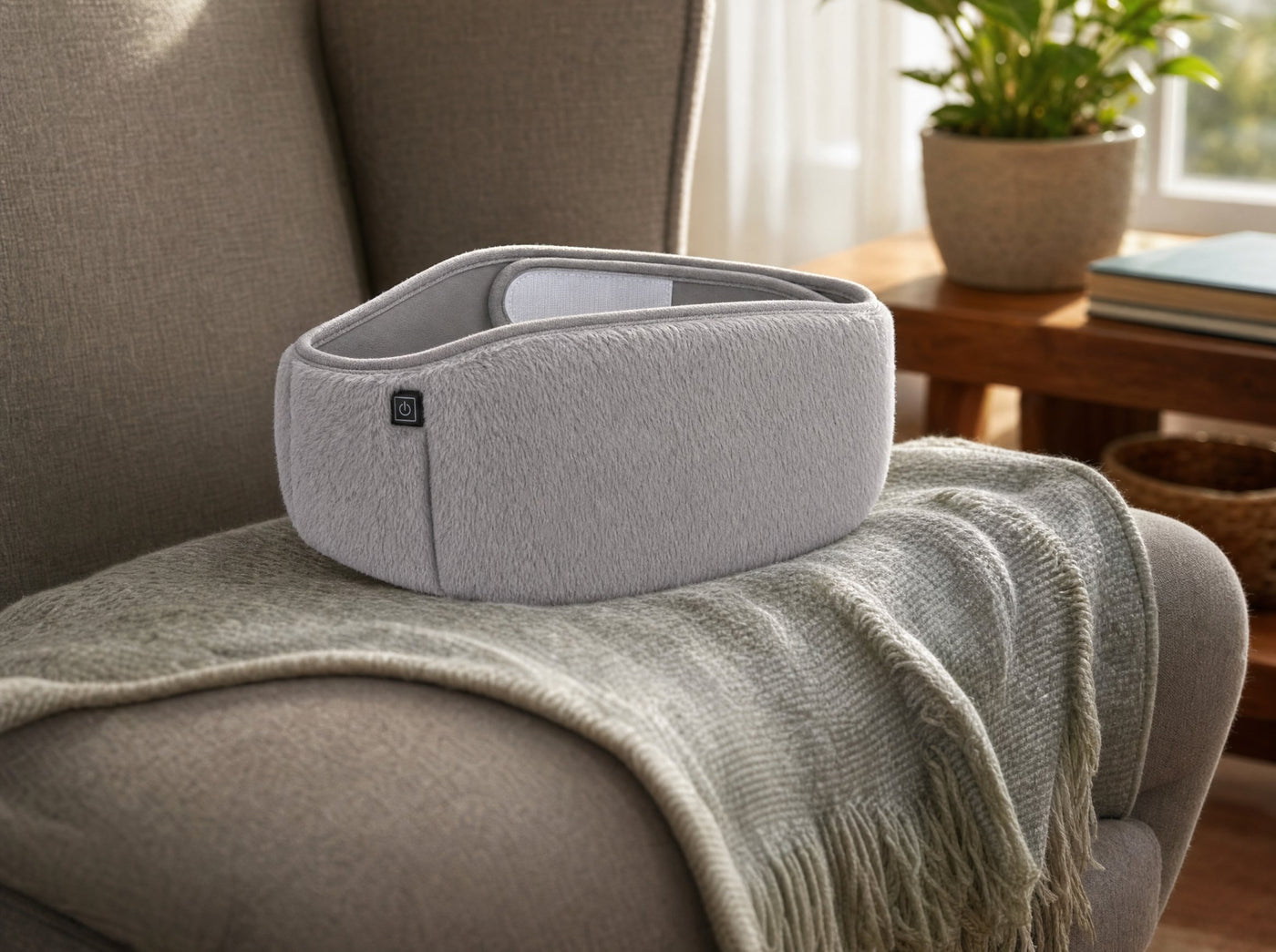 A quiet product-in-home still: the FuzzyPouch on a reading chair in soft daylight